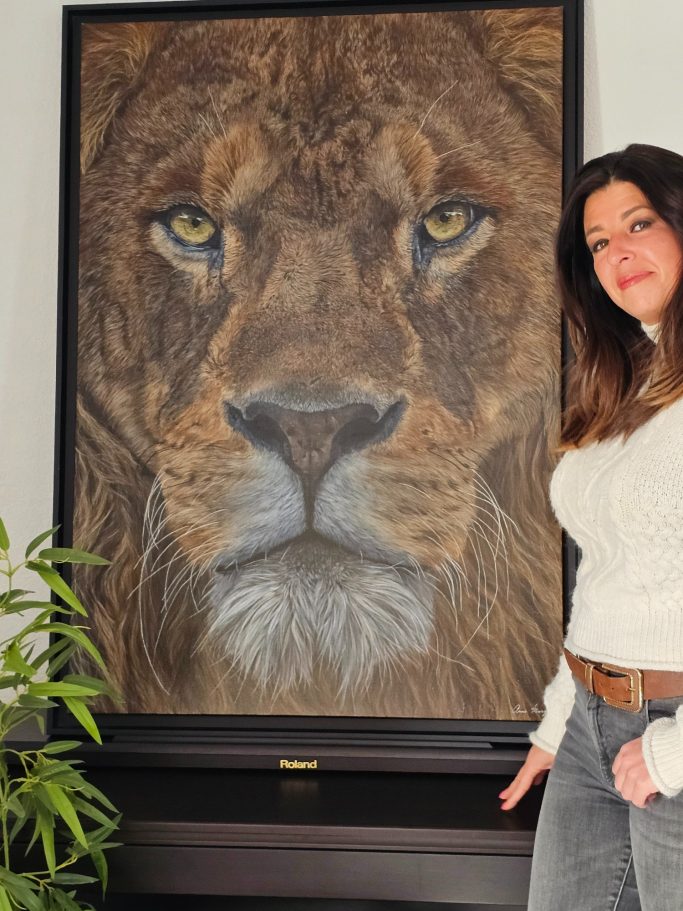 Femme posant à côté d'un grand portrait d'un lion réaliste.