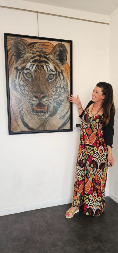 Anne Marguet posant devant sa toile du tigre du Bengale, peu avant la remise de l’œuvre à son nouveau propriétaire